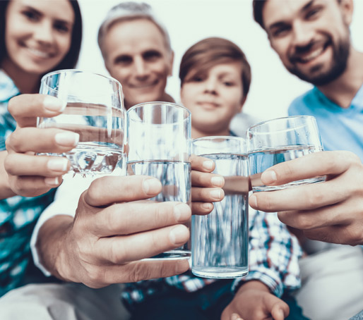 Les membres d'une famille dans la région de Montréal tenant tous un verre d'eau potable de qualité